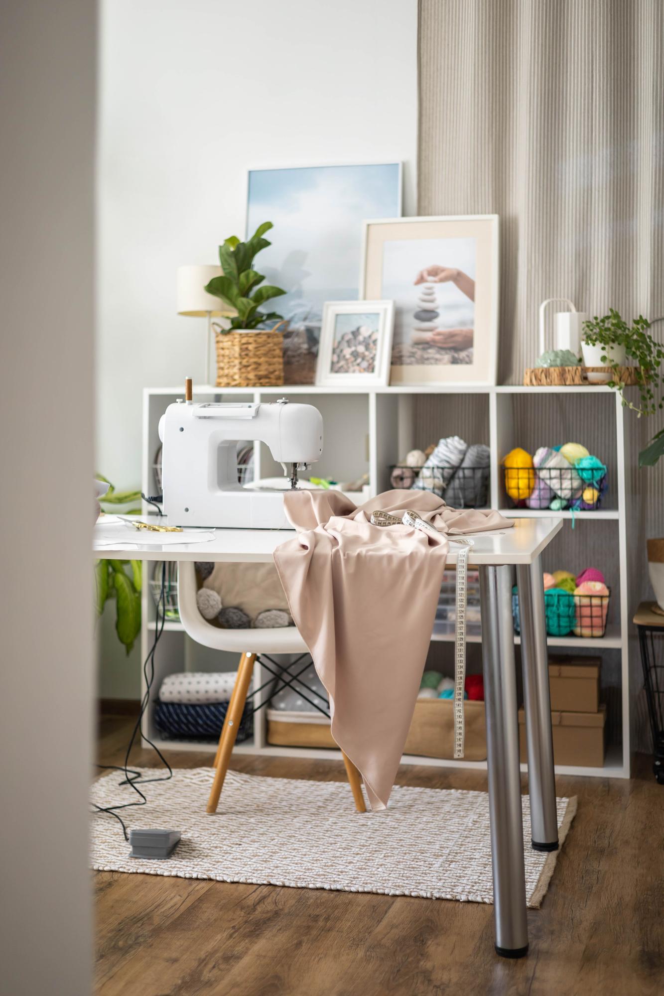 Interno atelier con tavolo da lavoro e ricami appesi